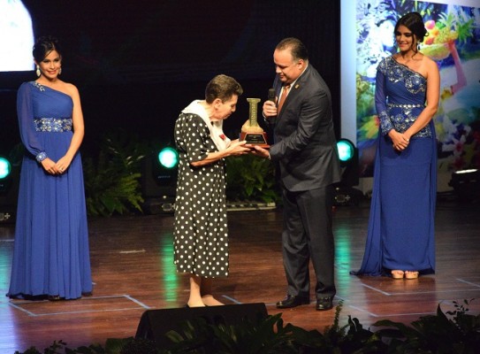 La poetisa Guillermina Cuellar recibe el premio identidad de las manos del alcalde sampedrano, Armando Calidonio.