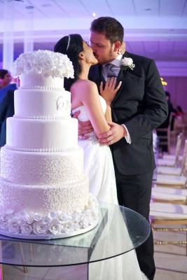 Una fabulosa imagen que refleja nítidamente el amor de los novios junto a su exquisito pastel de bodas elaborado por Hanan Canahuati