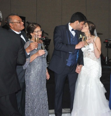 Una imagen adorable capturada durante el brindis de los recien casados, mientras los padres del novio son testigos de su amor...