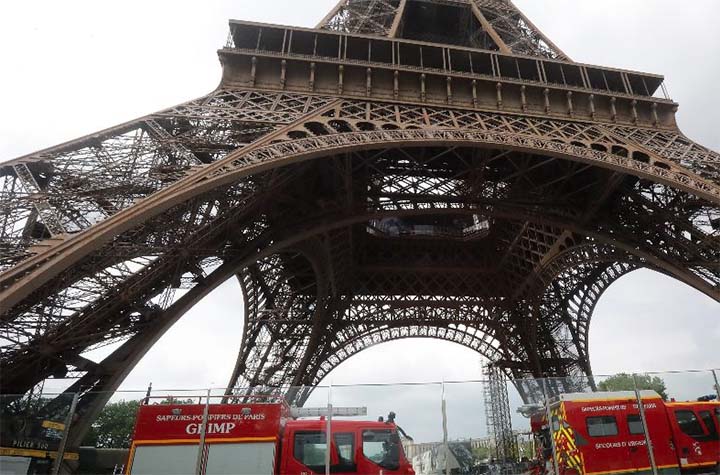 Cierran la Torre Eiffel y evacuan turistas por la presencia de un hombre escalando el monumento