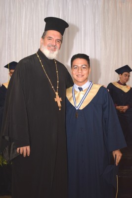 El graduado Mario Jafet Zelaya junto al padre Jorge Faraj