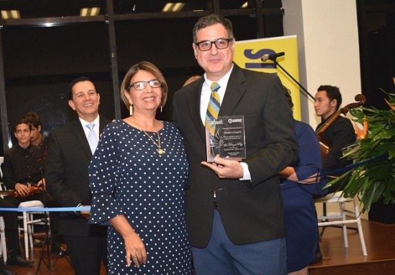 Gustavo Larach, uno de los homenajeados de la noche, cuando recibió el importante reconocimiento en manos de la señora Lucy Borjas.