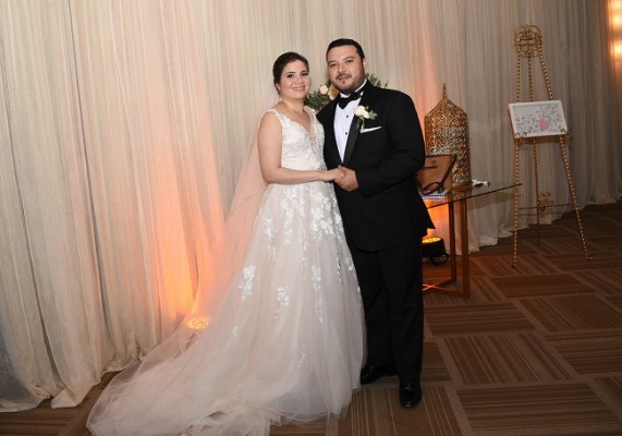 La novia lució delicada y romántica. En definitiva, absolutamente hermosa. Apostó por un vestido de la colección privada de Coral Gables; un diseño en tul con apliques rebordados en fina pedrería y escote V. Lo complementó con su bouquet, velo catedral, y un recogido desenfadado y maquillaje que esculpió en sus finas facciones Glenda Sánchez. Marlon se mostró como todo un caballero al enfundarse en su smoking oscuro.