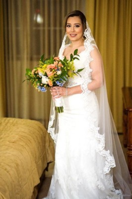 La novia lució preciosa y romántica. En definitiva, absolutamente hermosa. Apostó por un vestido de corte asirenado de la casa Novias de Blanco, con detalles rebordados en tul y escote V. Lo complementó con su velo catedral, un recogido desenfadado de Yolanda´s Salón y el maquillaje profesional de Mely Torres ¡bella!